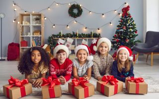 5 niños con un paquete de regalo cada uno en navidad