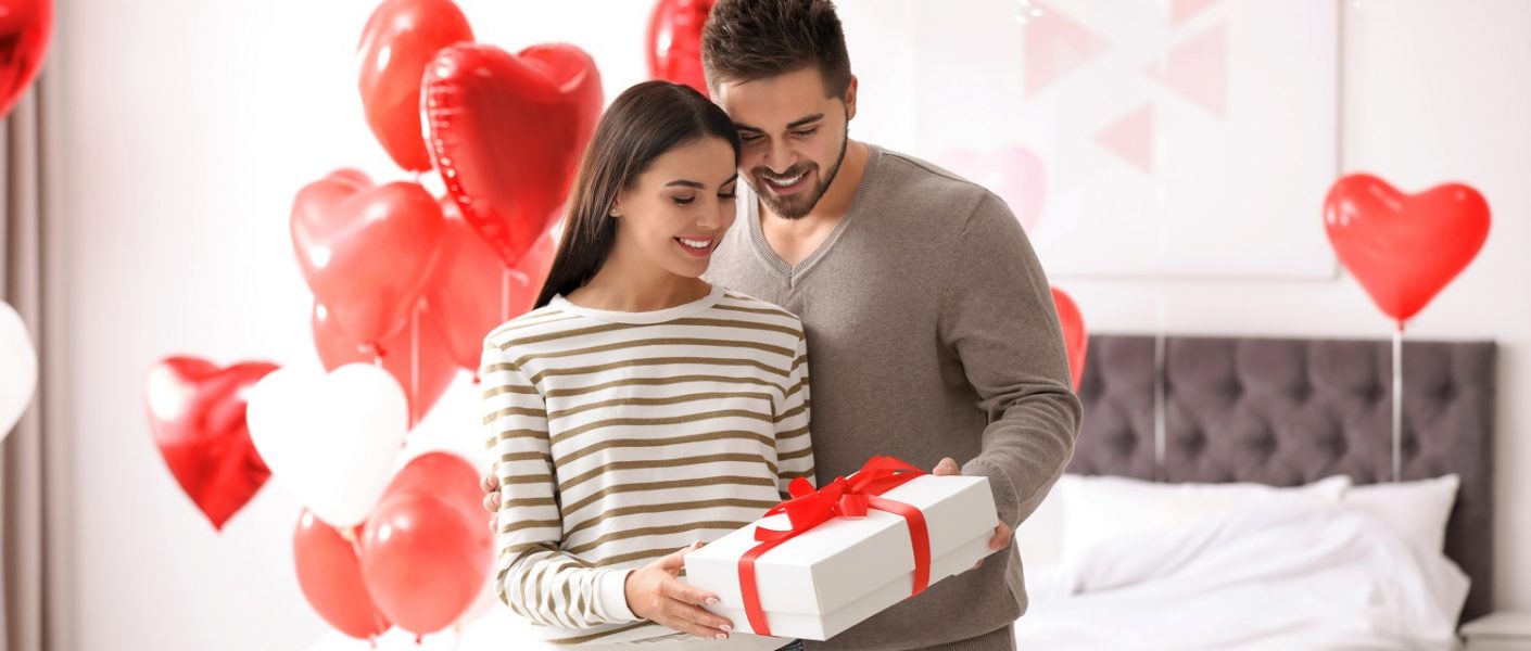 Pareja de enamorados en el día de San Valentín con un regalo