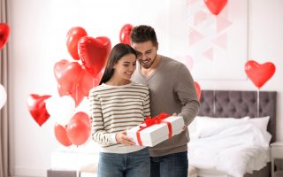 Pareja de enamorados en el día de San Valentín con un regalo