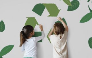 niñas con un mural de reciclaje