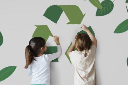niñas con un mural de reciclaje