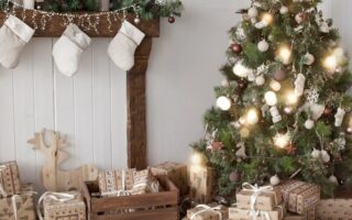 Comedor con árbol de navidad iluminado, chimenea y regalos