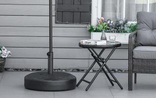 Mesa y sillón de jardín protegidos por una sombrilla con una base rellenable