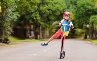 niño con patinete por un camino