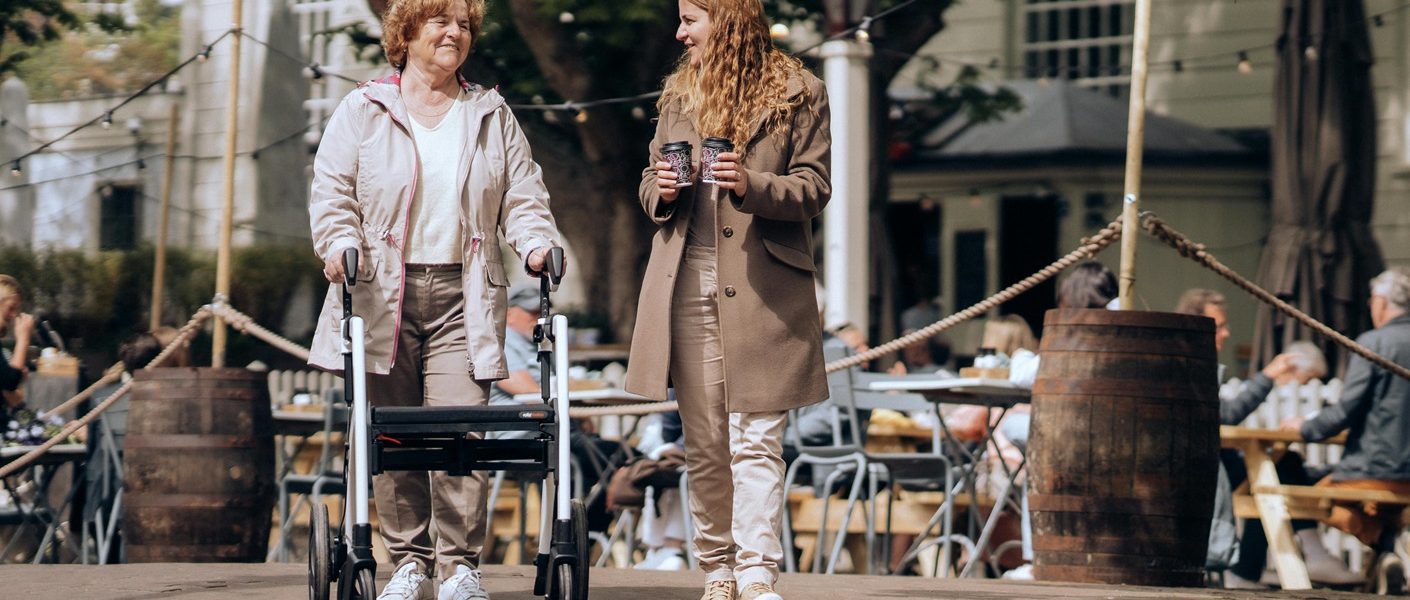 Señora con andador para adultos paseando con una mujer más joven