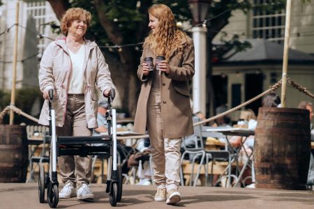 Señora con andador para adultos paseando con una mujer más joven