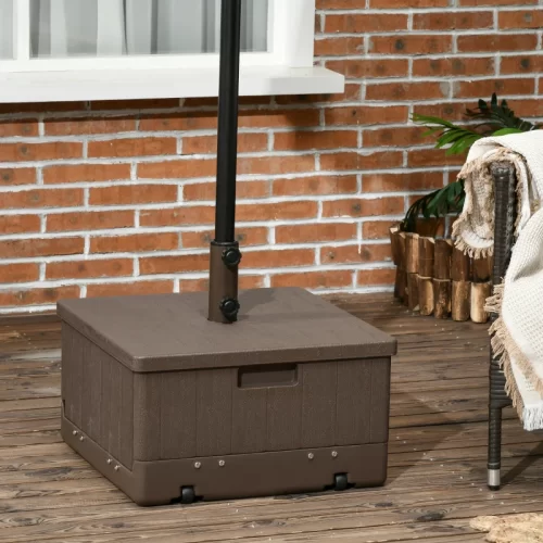 Base cuadrada marrón con ruedas sobre tarima de madera junto a sillón de exterior, las mejores bases de sombrilla para tu terraza o jardín.