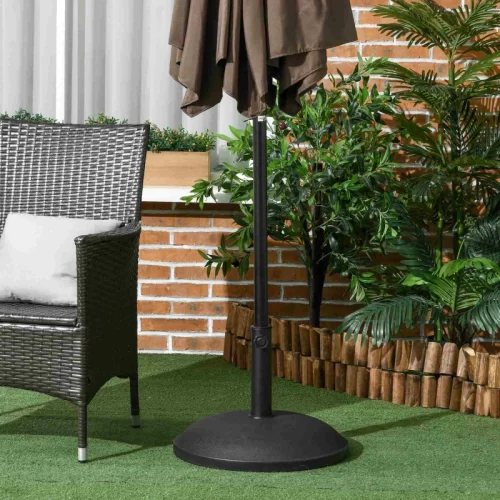 Base redonda de cemento negro sobre césped artificial junto a silla de ratán