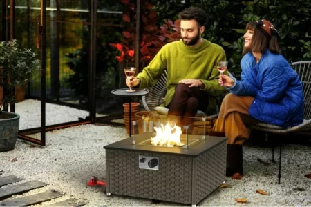 Chimenea de jardín encendida en un patio mientras una pareja conversa