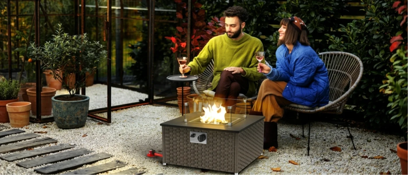 Chimenea de jardín encendida en un patio mientras una pareja conversa