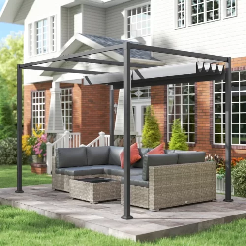 Pérgola de aluminio con toldo retráctil adosada a fachada de casa con zona de sofás de