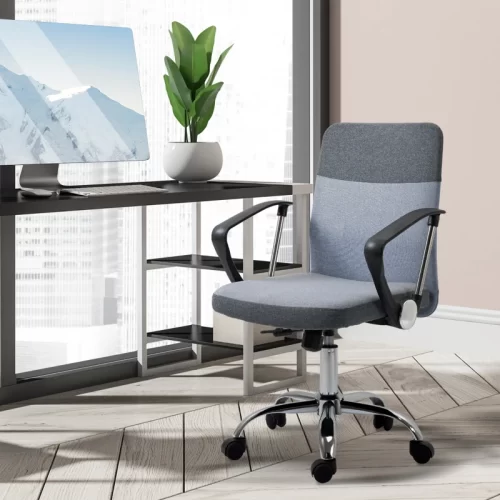 Silla de oficina de tela gris y azul junto a un escritorio situado frente a una ventana