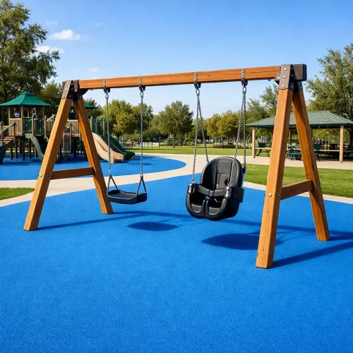 Pavimiento continuo de caucho azul debajo de unos columpios de un parque.