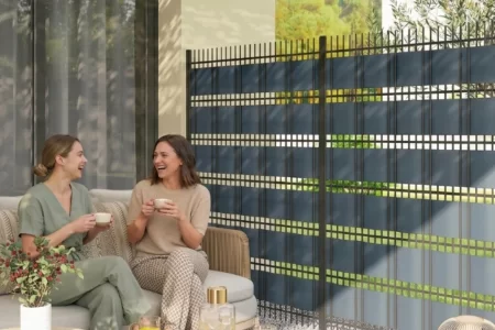 Dos mujeres charlando junto a una valla de privacidad de rejilla