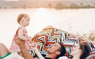 Familia relajándose en una hamaca junto al lago