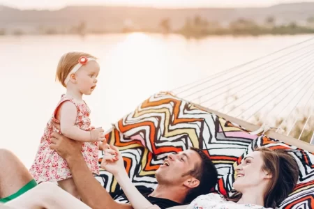 Familia relajándose en una hamaca junto al lago