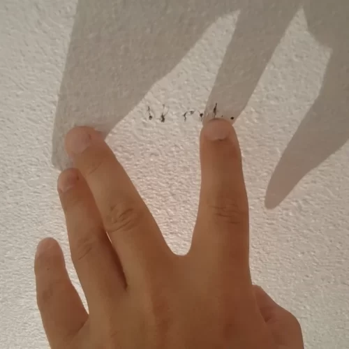 Mano señalando los agujeros de prueba en el techo para localizar la anchura de la viga.