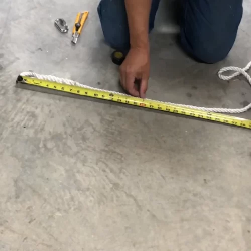 Midiendo y marcando la cuerda de la silla hamaca con una cinta métrica.