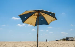 Sombrilla de playa con la tela rasgada y agujeros
