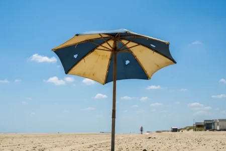 Sombrilla de playa con la tela rasgada y agujeros