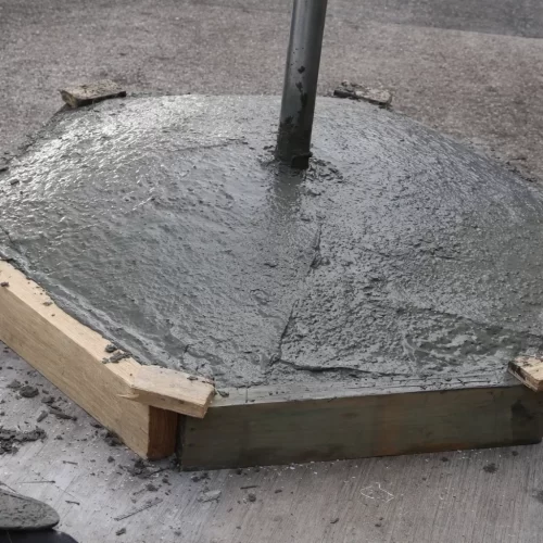 Base de cemento curando dentro del molde de madera hexagonal antes de retirar los paneles