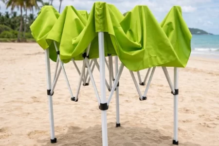 Carpa gazebo de color verde completamente plegada y de pie en la playa 1400