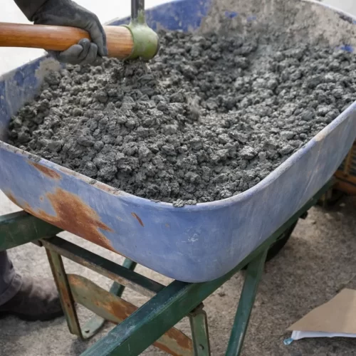 Carretilla con cemento recién mezclado listo para verter en el molde de la base