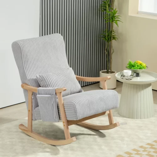 Mecedora tapizada en gris con patas de madera junto a una mesa auxiliar