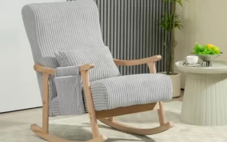 Mecedora tapizada en gris con reposabrazos de madera y cojín lumbar en el saló