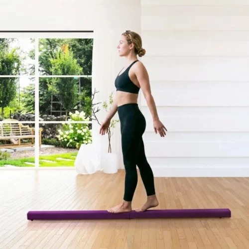Mujer en equilibrio estático sobre una barra de equilibrio púr