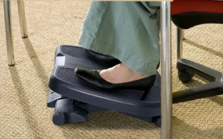 Reposapiés negro bajo un escritorio con zapato de tacón apoyado 1400