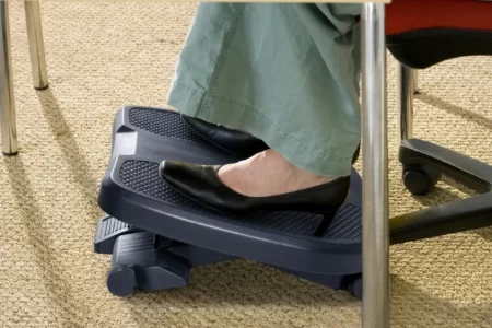Reposapiés negro bajo un escritorio con zapato de tacón apoyado 1400