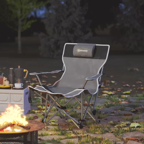 Silla de camping plegable Outsunny con reposacabezas junto a una hoguera al anochecer