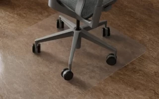 Silla de oficina con ruedas sobre alfombrilla transparente en suelo de piedra
