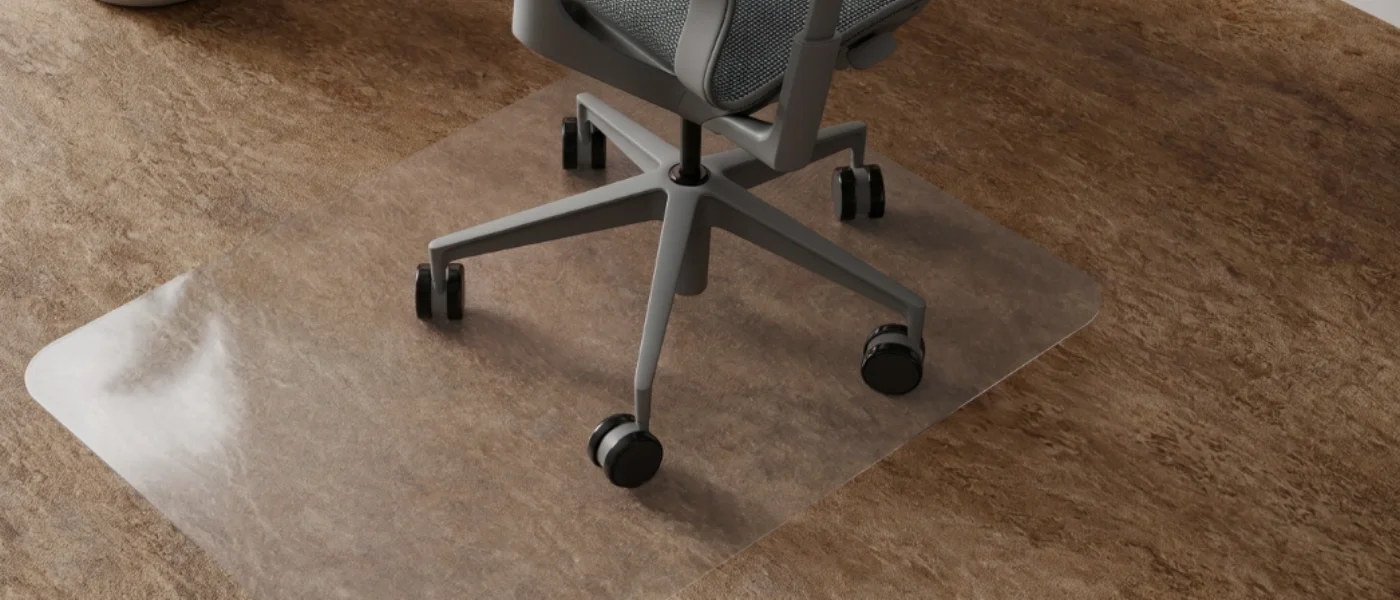 Silla de oficina con ruedas sobre alfombrilla transparente en suelo de piedra