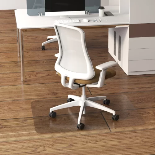 Silla de oficina con ruedas sobre alfombrilla transparente junto al escritorio