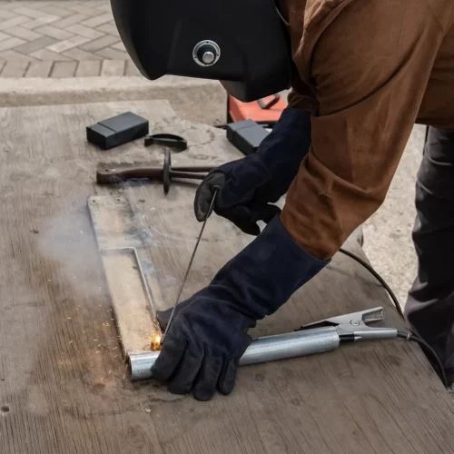Soldadura de las patas de varilla al tubo central para formar la estructura de la base