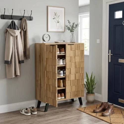Zapatero de madera junto a la puerta de entrada de una casa