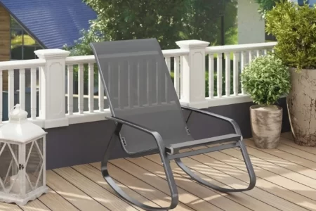 Mecedora de mimbre en una terraza acristalada rodeada de plantas 1400