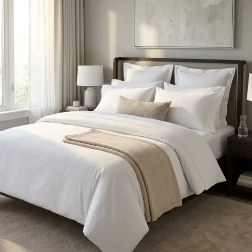 Cama de matrimonio vestida de blanco con manta beige
